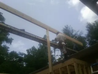 Carpenter setting a ridge beam over a new addition frame — Ice Dam Removal by Roofing Brothers in Granite Quarry