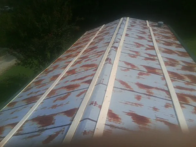 Rusted metal roof panels with new wood purlins before replacement — Storm Damage Roof Repair in Granite Quarry by Roofing Brothers
