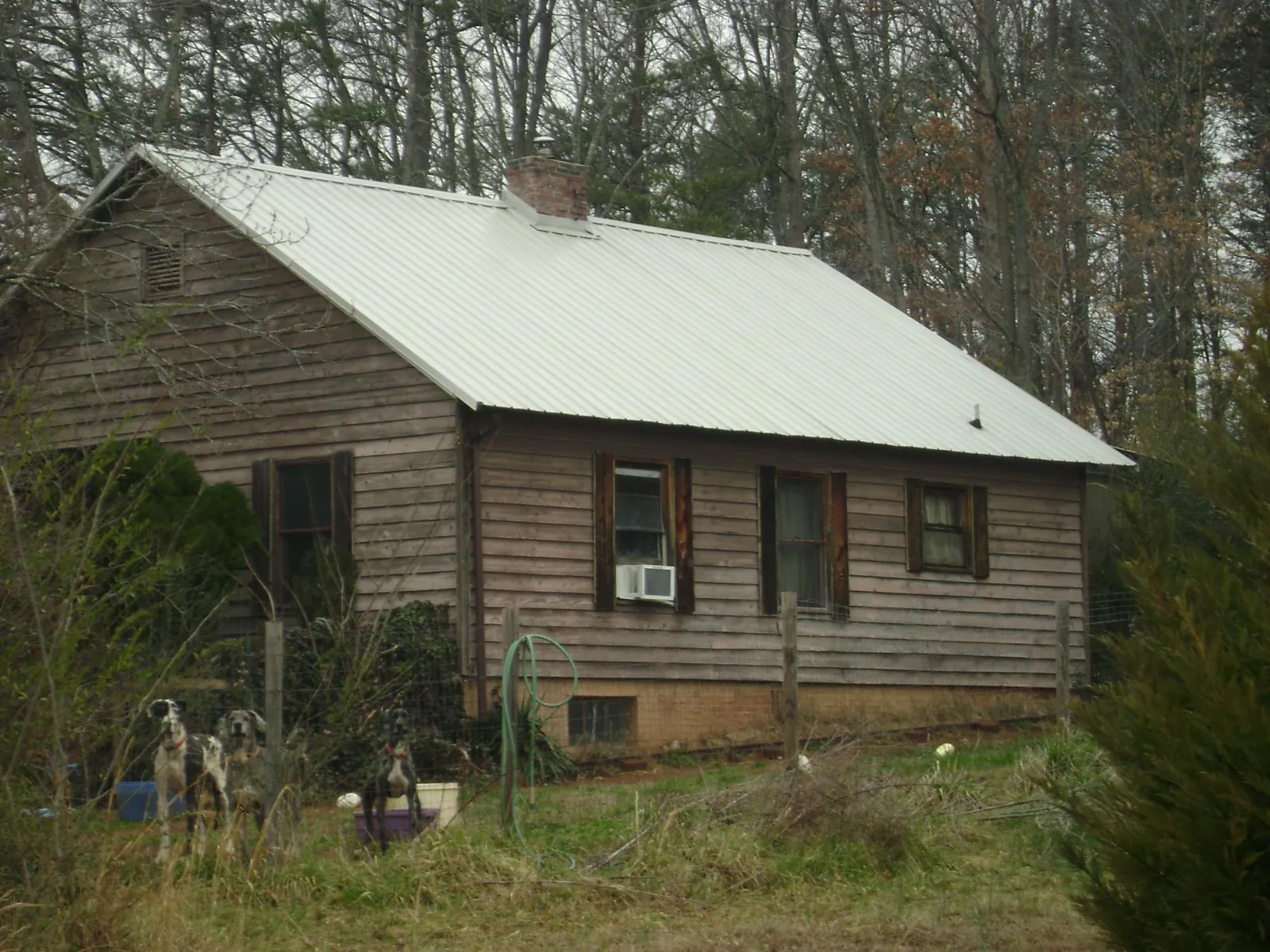 White metal roof on an old wood sided farmhouse, from a Metal Roof Installation job in Granite Quarry